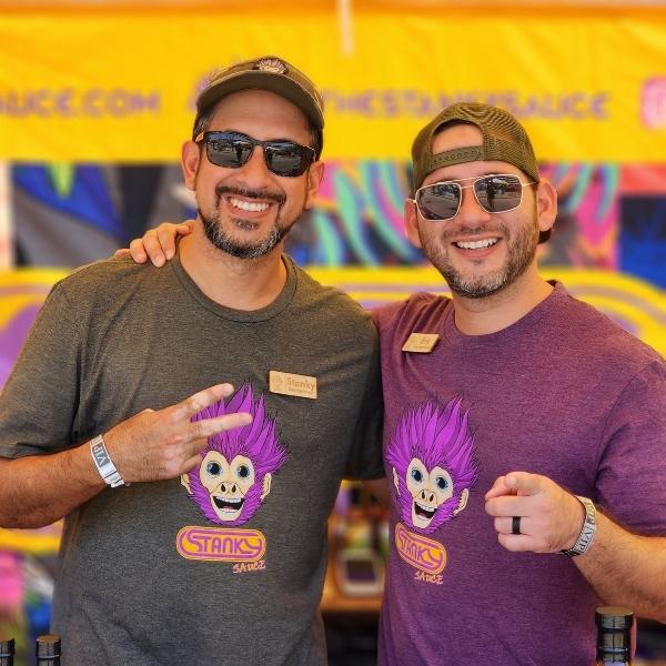 The Stanky Brothers smiling and wearing Stanky Sauce t-shirts while pointing at the camera