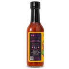 The description panel of a bottle of Stanky Sauce The Clásico Hot Sauce, featuring a heat meter, food pairing recommendation and business and social media information. Also says to Shake Well and Refrigerate After Opening.
